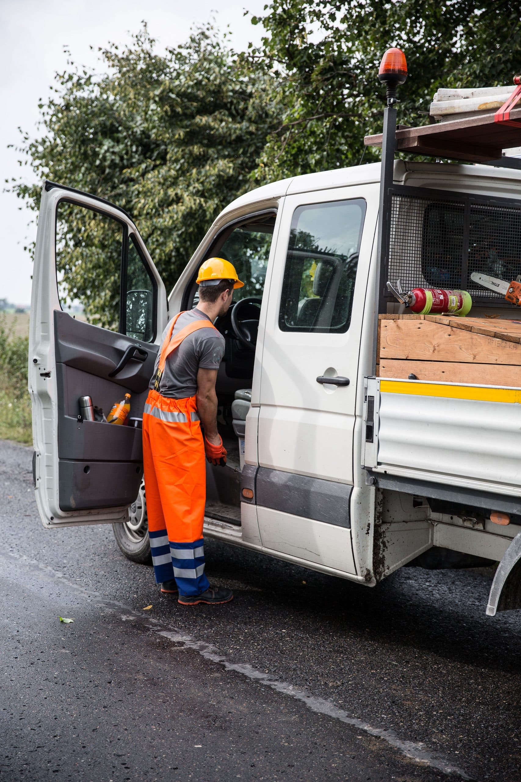 A worker in hi-vis beside a work van